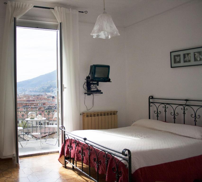 um quarto com uma cama e uma varanda com uma televisão em APT Il Rifugio del Marinaio em La Spezia