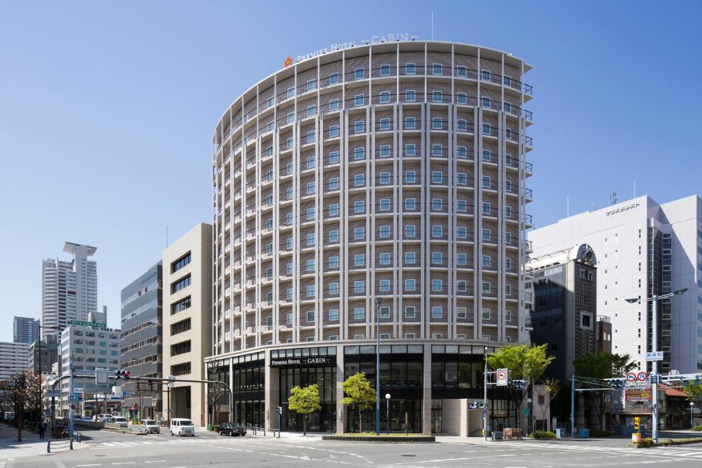 a tall building in a city with buildings at Premier Hotel CABIN PRESIDENT Osaka in Osaka