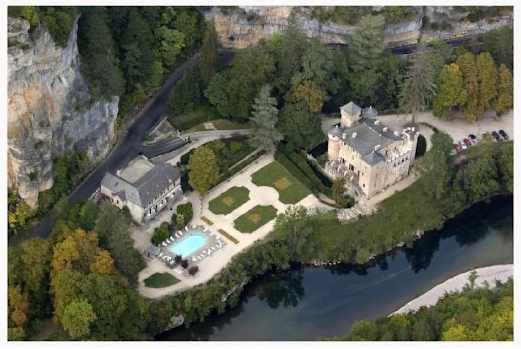 an aerial view of a house on a island in the water at Chateau De La Caze in Sainte-Énimie