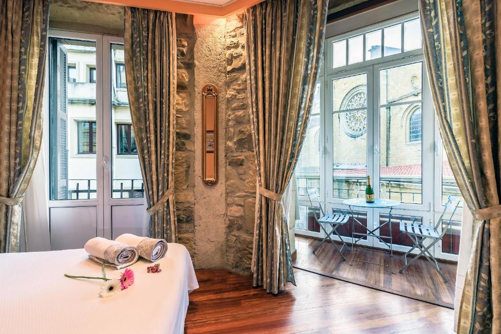 サン・セバスティアンにあるペンシオン アブ ドミニのベッド1台と大きな窓が備わる客室です。