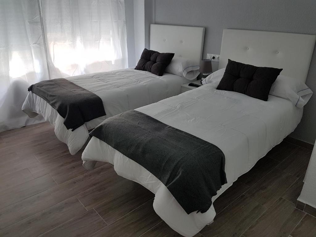 dos camas sentadas una al lado de la otra en un dormitorio en Guesthouse Central, en Alicante