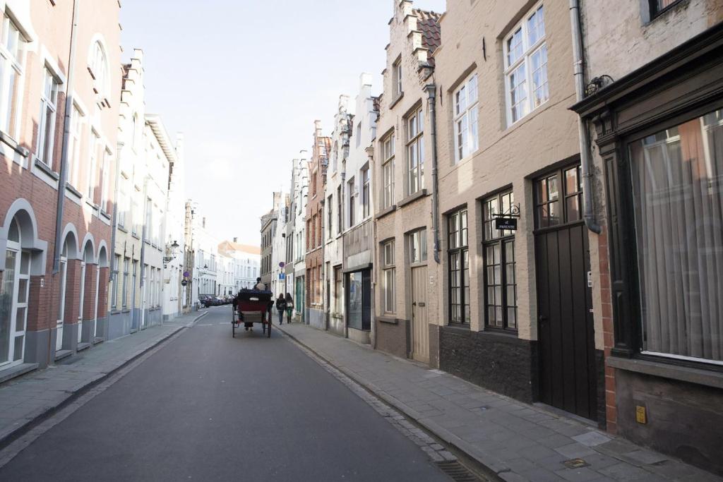 um beco com uma carruagem puxada por cavalos numa rua da cidade em The Abiente Rooms em Bruges