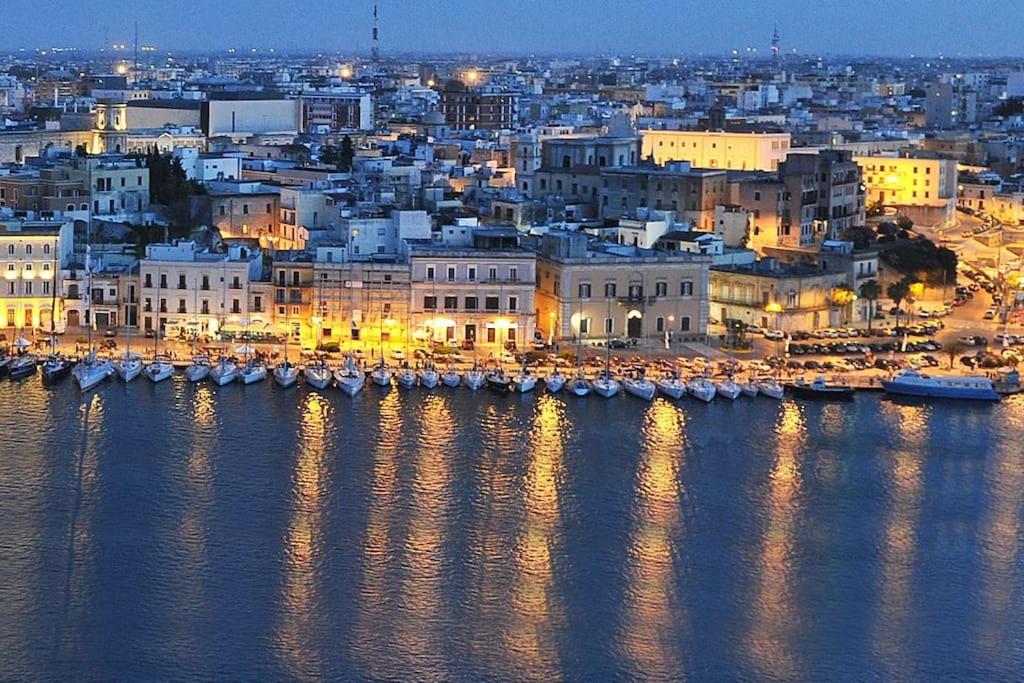 a city at night with boats in the water at la loggia in Brindisi