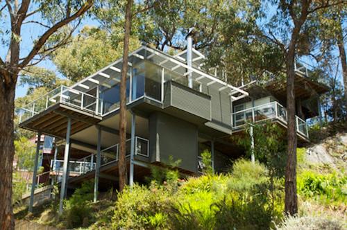 a large house on top of a hill with trees at Lorne Luxury in Lorne