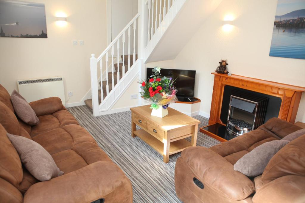 a living room with a couch and a fireplace at Harbour Cottage in Stromness