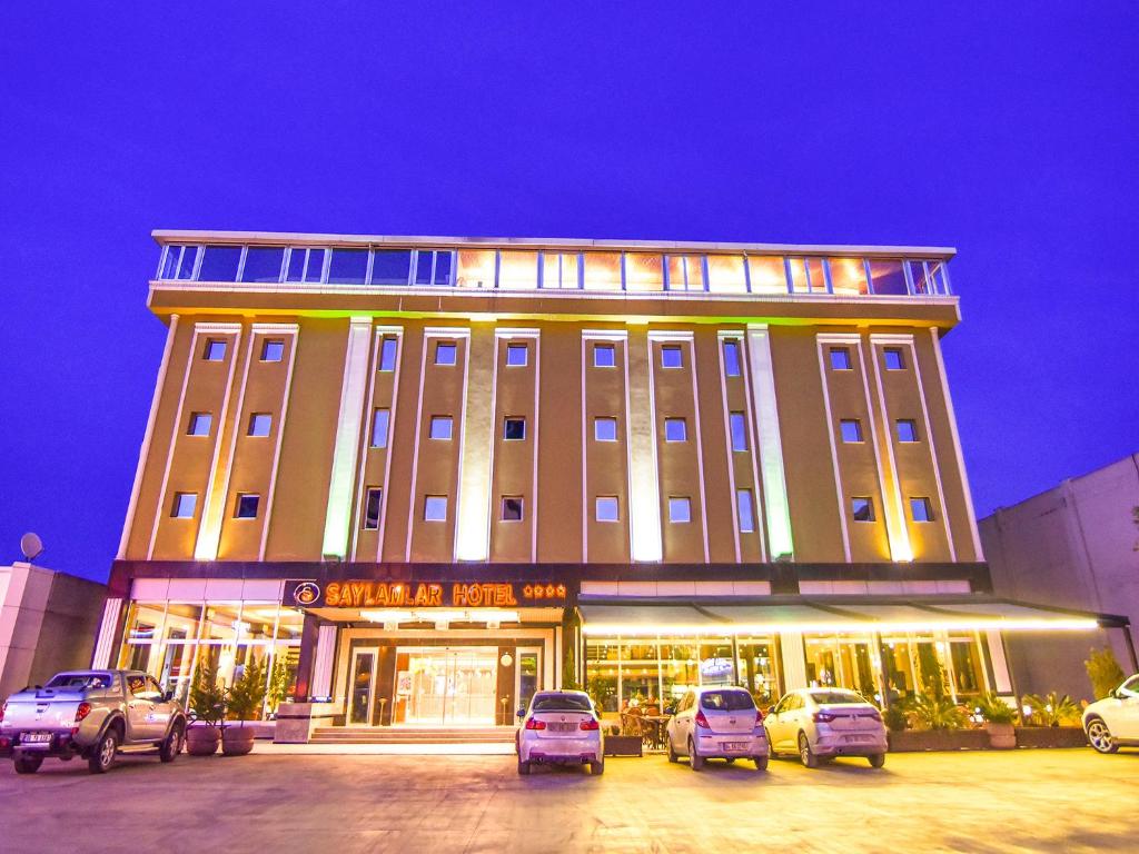 un grand bâtiment avec des voitures garées devant lui dans l'établissement Saylamlar Hotel, à Trabzon