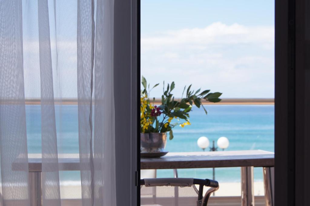 stół z rośliną i widokiem na ocean w obiekcie Terra Kotta w mieście Paralia Vrachou