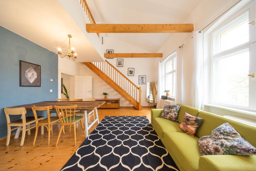 een woonkamer met een groene bank en een tafel bij Design Apartments - "Am Jägertor" in Potsdam