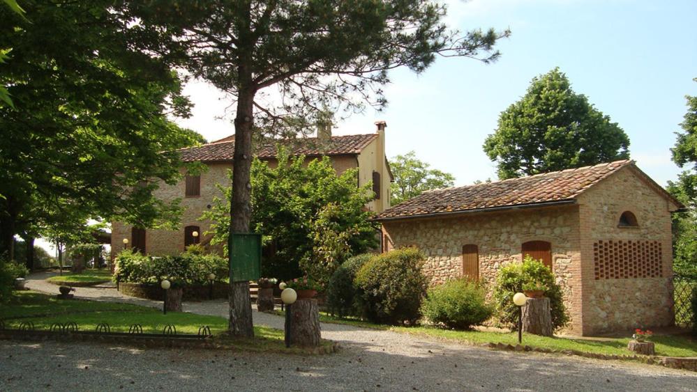 una casa con un árbol delante de ella en Agriturismo il Prato, en Palaia