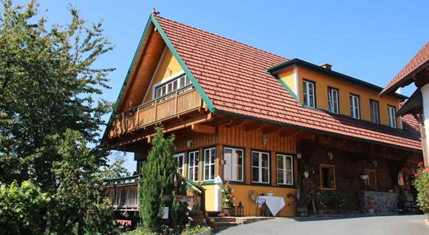 a large wooden house with a red roof at Weingut Schatz in Heimschuh