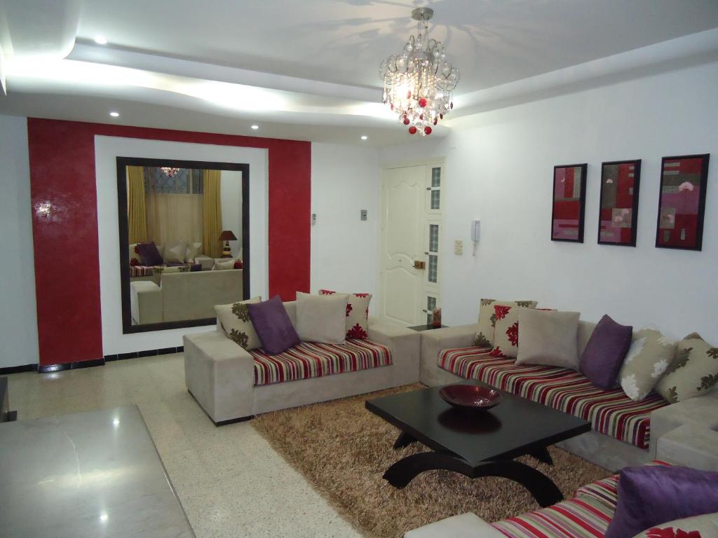 a living room with two couches and a table at Appartement standing Nabeul in Nabeul