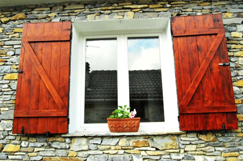 uma janela com um vaso de plantas numa parede de pedra em L'Antico Frantoio em Rapallo