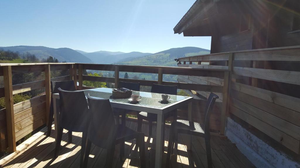 une table et des chaises sur le balcon d'une maison dans l'établissement les Genêts, à La Bresse