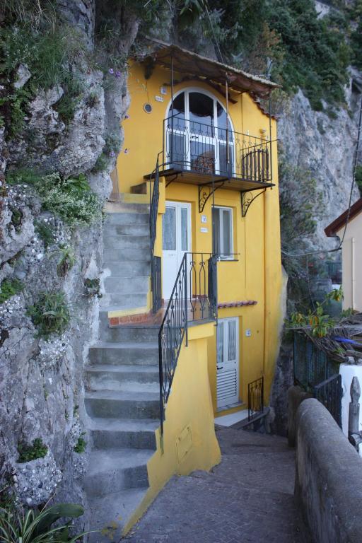 a yellow house with stairs leading up to it at Casa Reginella - Borgo Marinaro in Conca dei Marini