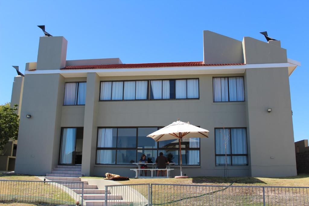 a building with an umbrella in front of it at The Port Owen Holiday House in Velddrif