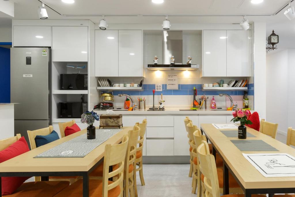 uma cozinha e sala de jantar com mesas e cadeiras em Myeongdong Sunshine Guesthouse em Seul