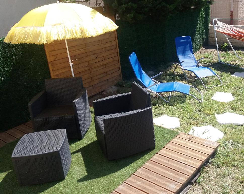 a group of chairs and an umbrella and chairs at Petite Chouette in Salses-le-Chateau