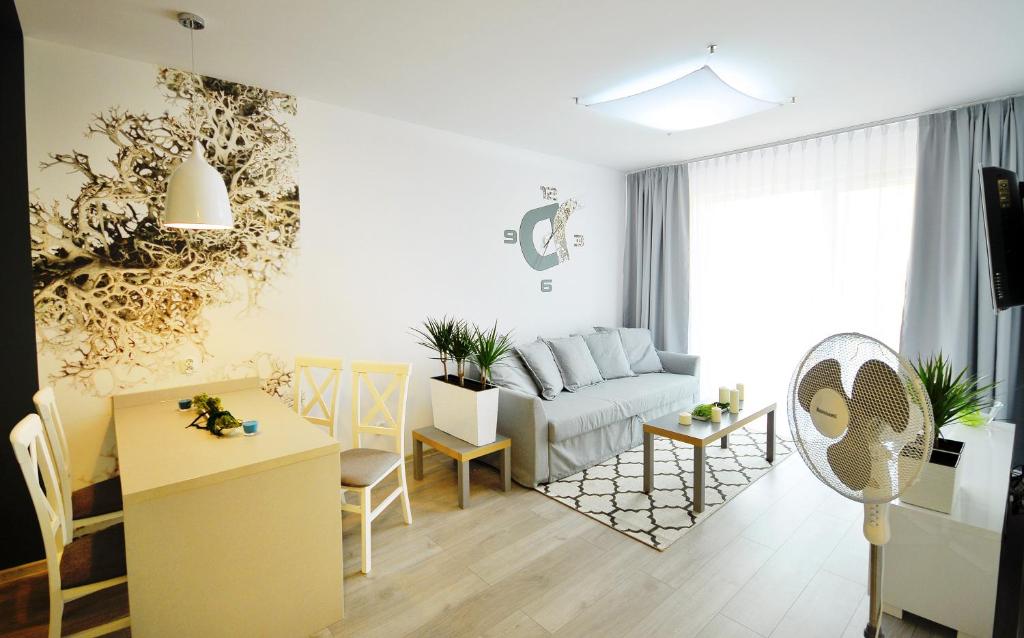 uma sala de estar com um sofá e uma mesa em Apartamenty REZULAK Solna B104 204 303 em Kolobrzeg