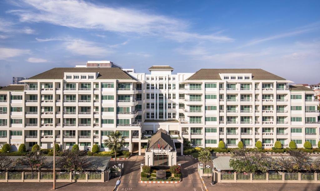 un gran edificio blanco con una iglesia delante en Somerset Vientiane en Vientián