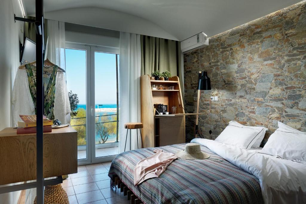 - une chambre avec un lit et une grande fenêtre dans l'établissement Hotel Menel The Tree House- Adults only, à Limenaria
