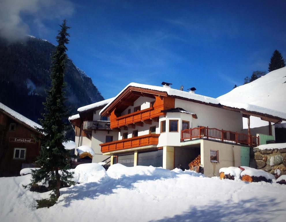 a building with snow on the ground in front of it at Bauernhof Entalhof in Finkenberg