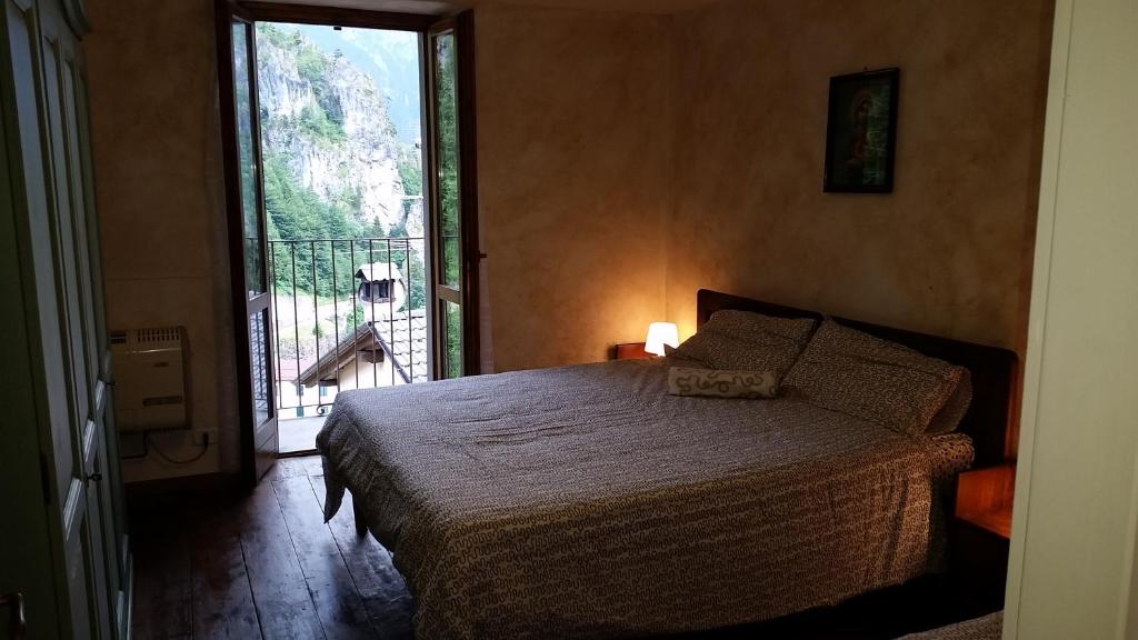 a bedroom with a bed and a large window at casa del cirillo in Ornica