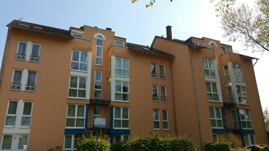 an orange building with white windows and a tree at Apartmentcenter Koblenz in Koblenz