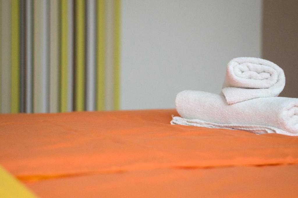 una pila di asciugamani poggiata sopra un letto di Berkes Vendégház a Badacsonytördemic