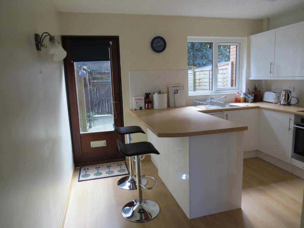 uma cozinha com um balcão e um banco de bar em Taverner - Self catering holiday home close to Poole Quay em Poole