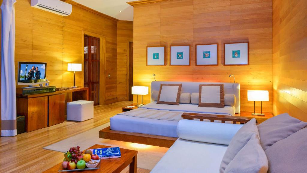 a large bedroom with a bed and a couch at Adaaran Prestige Water Villas - with Dine around Premium All inclusive - 24 hours in Raa Atoll