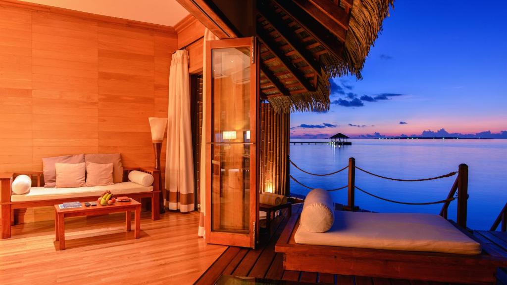 a room with a balcony with a view of the water at Adaaran Prestige Water Villas - with Dine around Premium All inclusive - 24 hours in Raa Atoll