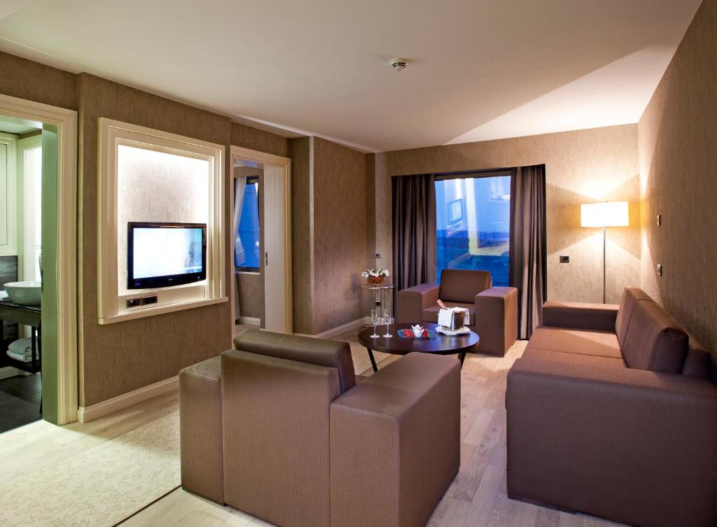 a living room with a couch and a tv at Limak Eurasia Luxury Hotel in Istanbul