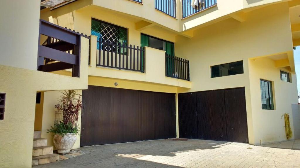 a large house with a garage and a balcony at Canto da Praia in Itajubá