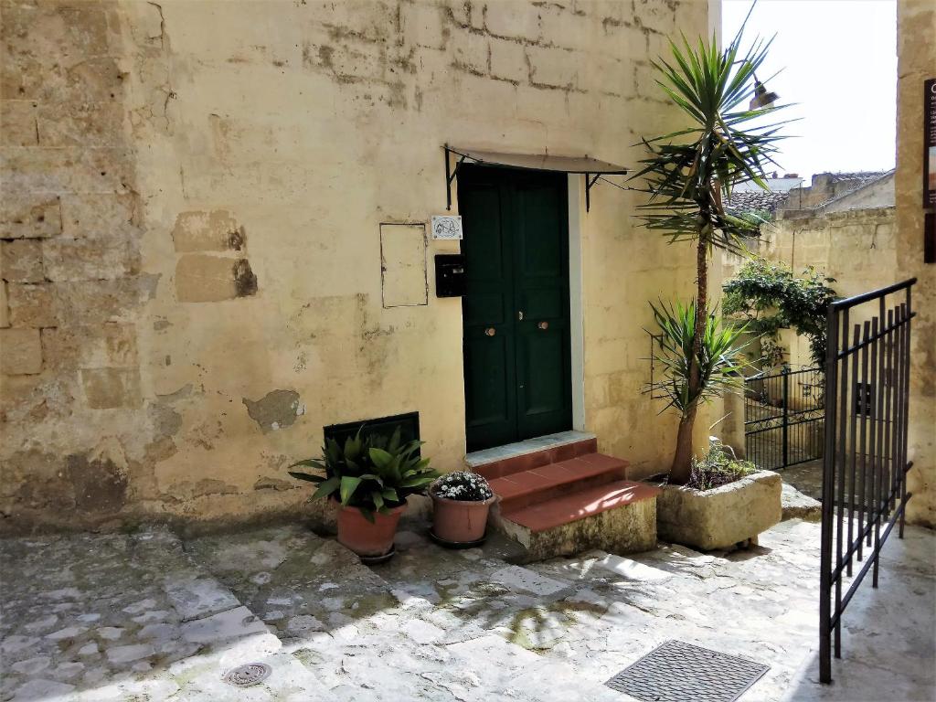 マテーラにあるNei Sassi da Ninoの鉢植えの建物の緑の扉