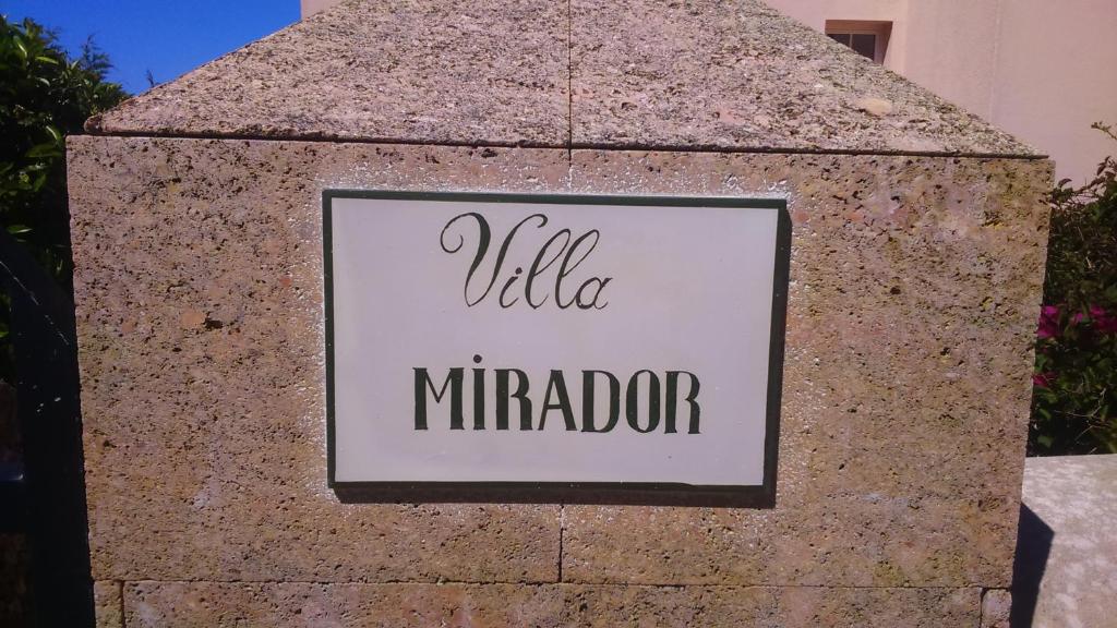 a sign on a stone wall with the word villa mirdor at Villa PANORAMA y Villa MIRADOR in Son Bou