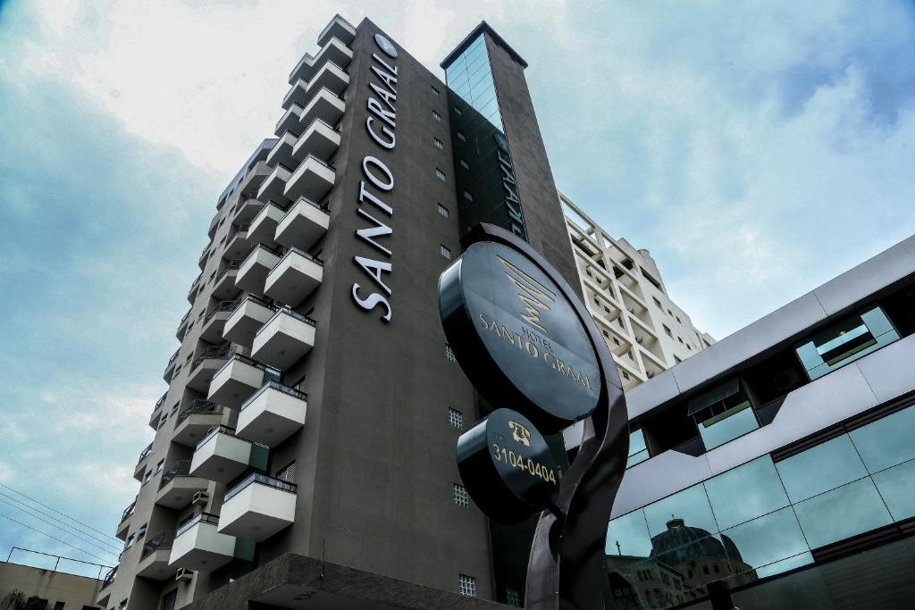 a tall building with a sign in front of it at Hotel Santo Graal in Aparecida