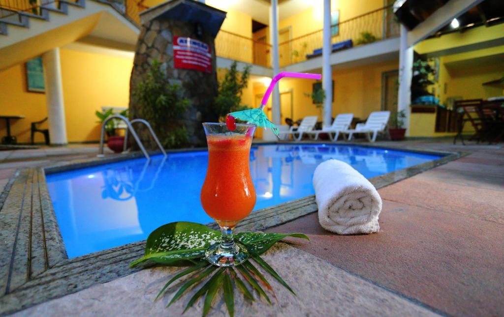 a drink sitting on a table next to a swimming pool at Marlim Porto Hotel in Porto Seguro