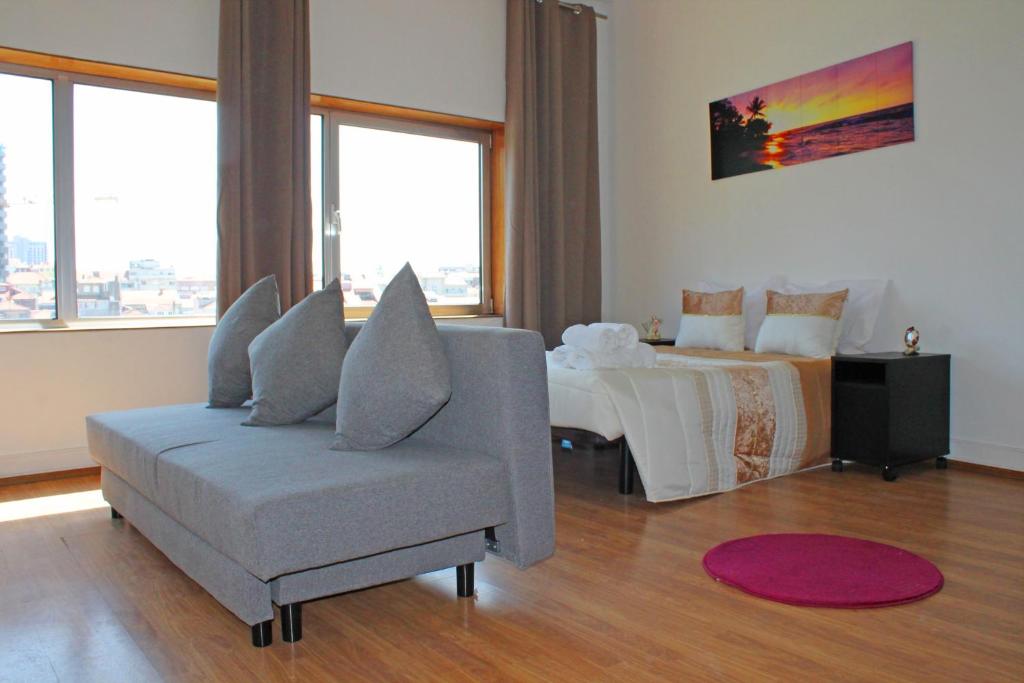 een woonkamer met een bank en een bed bij Trindade Oporto Apartments Group in Porto