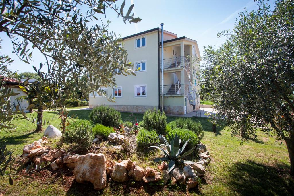 a house with a garden in front of it at Apartments Jelena in Nova Vas