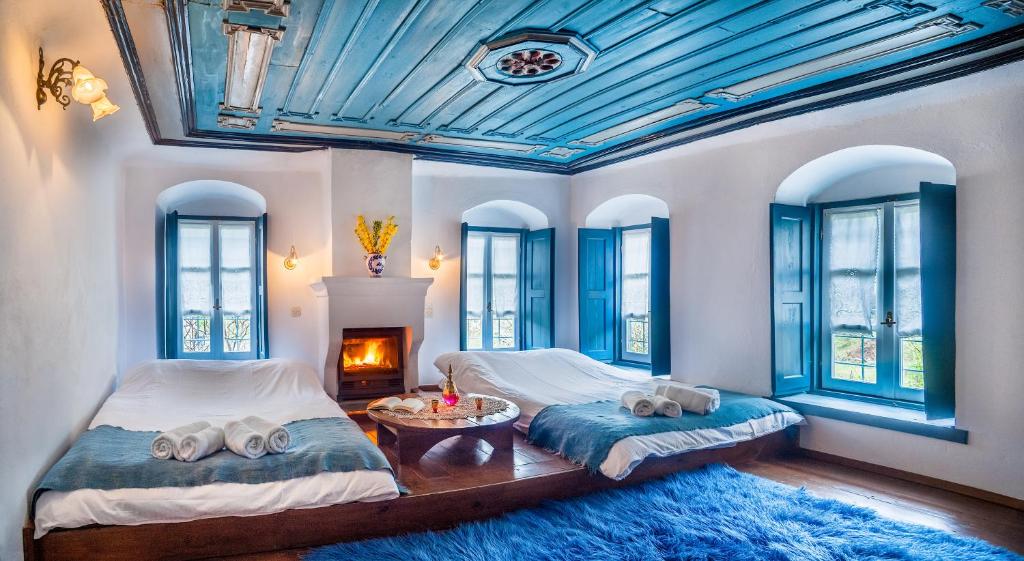 two beds in a room with blue ceilings and windows at Guesthouse Ioannidis in Papingo
