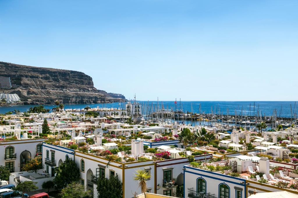 a beach with a large body of water surrounded by buildings at Apartamentos Puerto de Mogán THe Home Collection in Puerto de Mogán