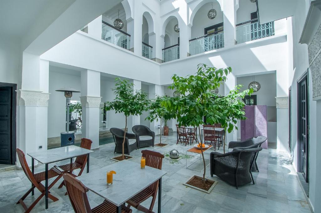uma sala de estar com mesas e cadeiras em Riad Sapphire & Spa em Marrakech