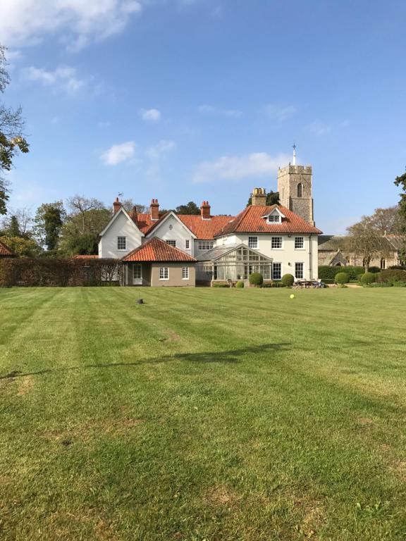 a large yard with a large house in the background at The Old Rectory in Campsey Ash