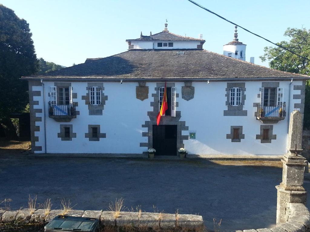 Pazo Vilabade في Vilabade: بيت ابيض كبير عليه سهم احمر