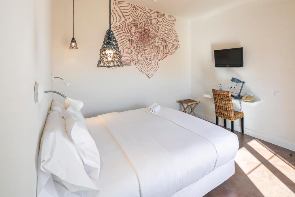 a white bedroom with a bed and a table at Costa d'Oiro Ambiance Village in Lagos