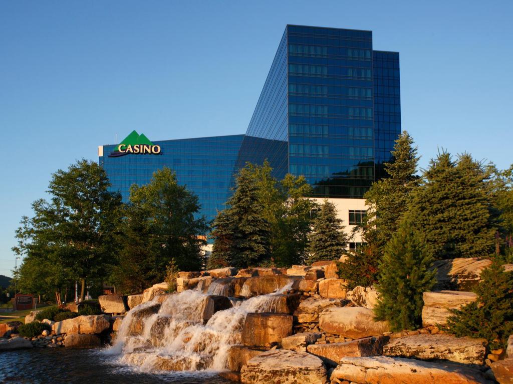 a waterfall in front of a building next to a river at Seneca Allegany Resort & Casino in Salamanca