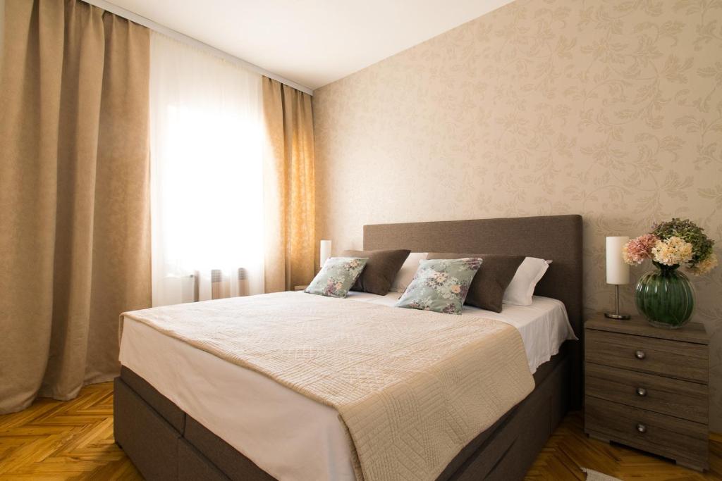 Un dormitorio con una cama con un jarrón de flores. en Holiday Home Lucija, en Biograd na Moru