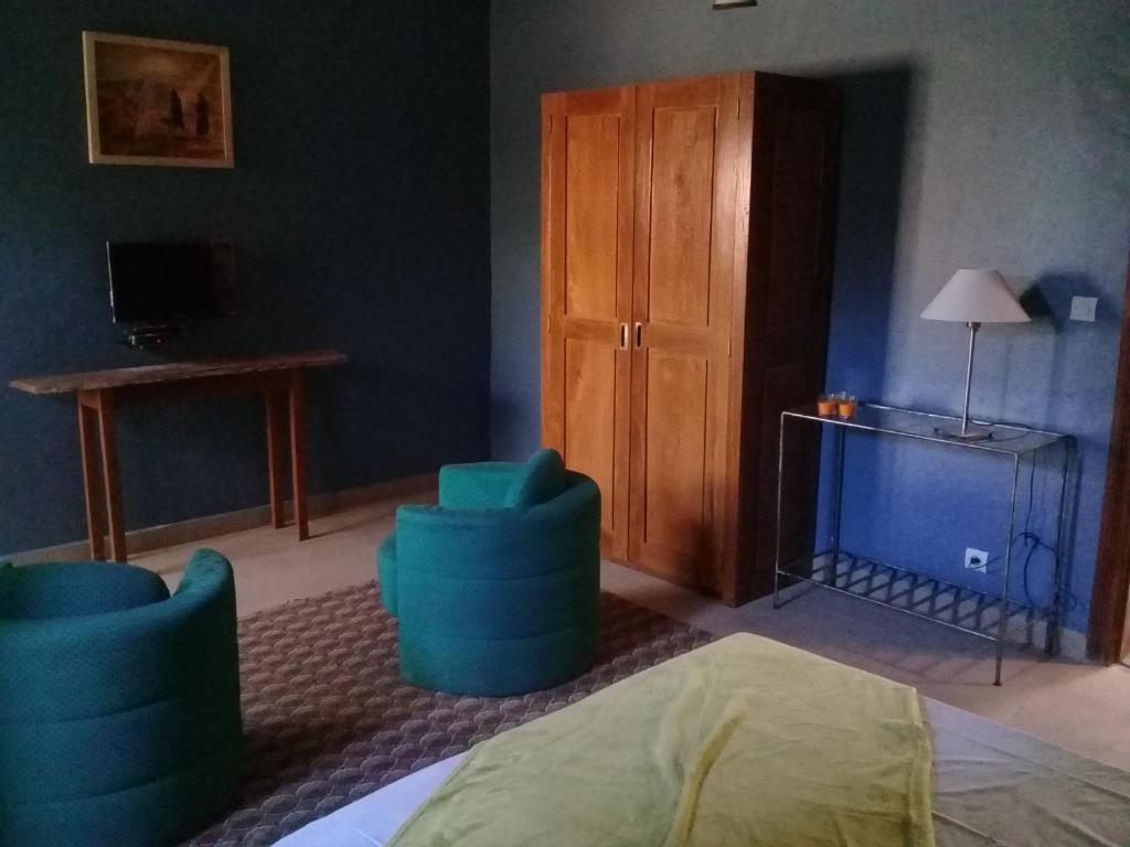 un soggiorno con sedie blu e TV di Les 5 lanternes by Clara a Dakar