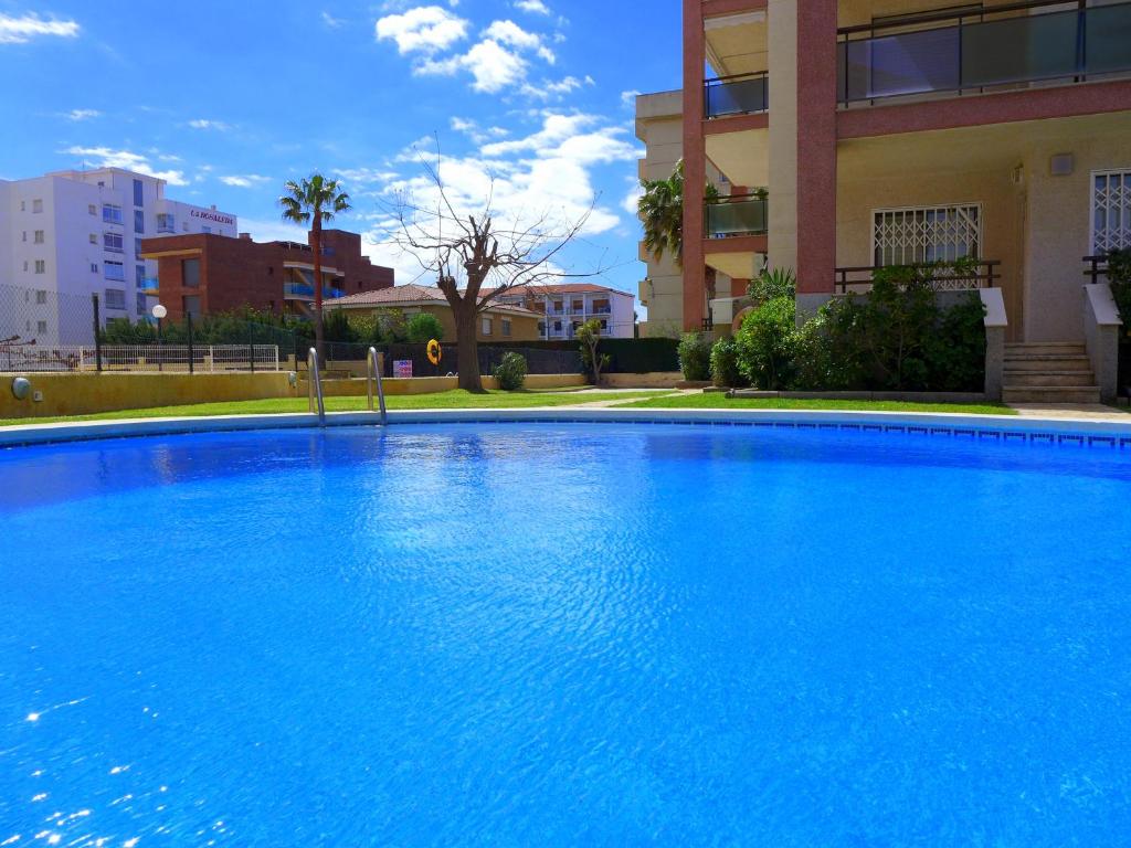 Una gran piscina azul frente a un edificio en Rentalmar Amanecer, en Miami Platja