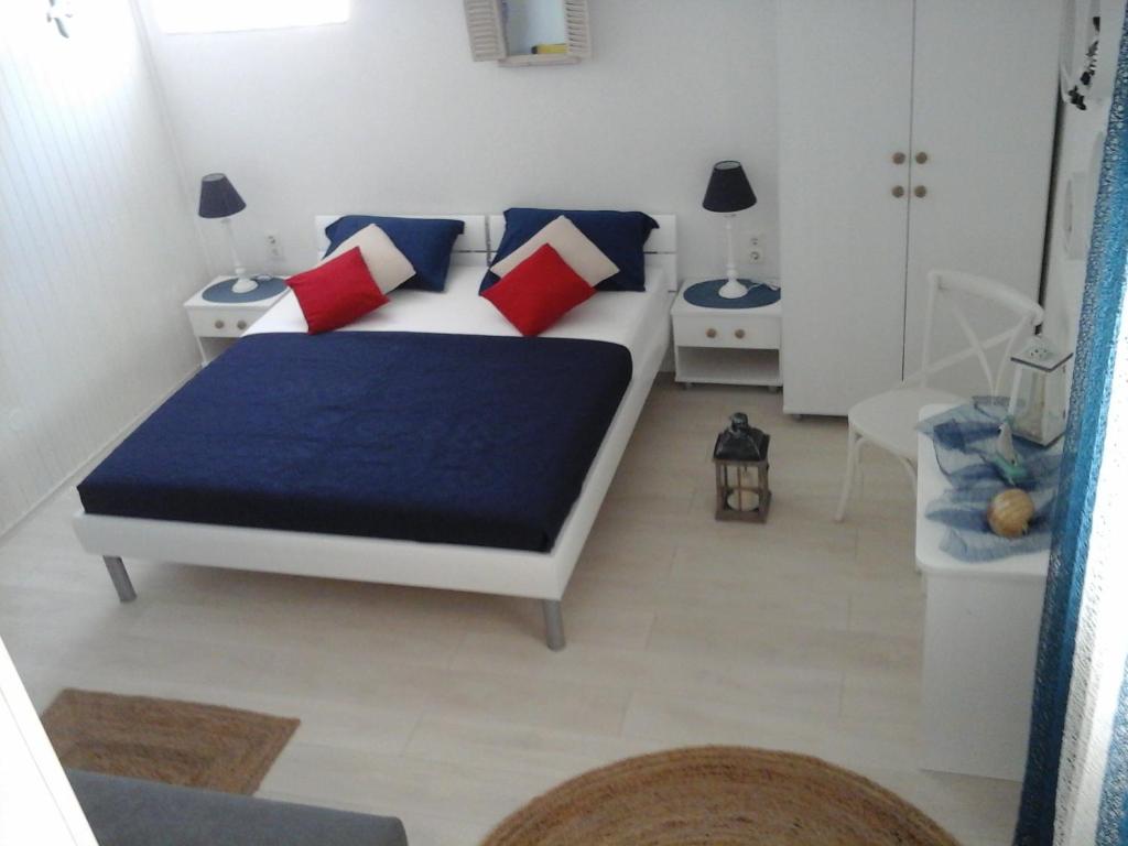 1 dormitorio con 1 cama con almohadas azules y rojas en Apartments Teo, en Hvar